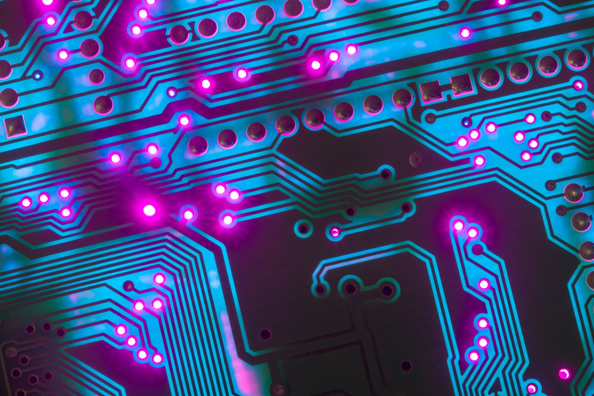 Circuit board lit in blue and magenta
