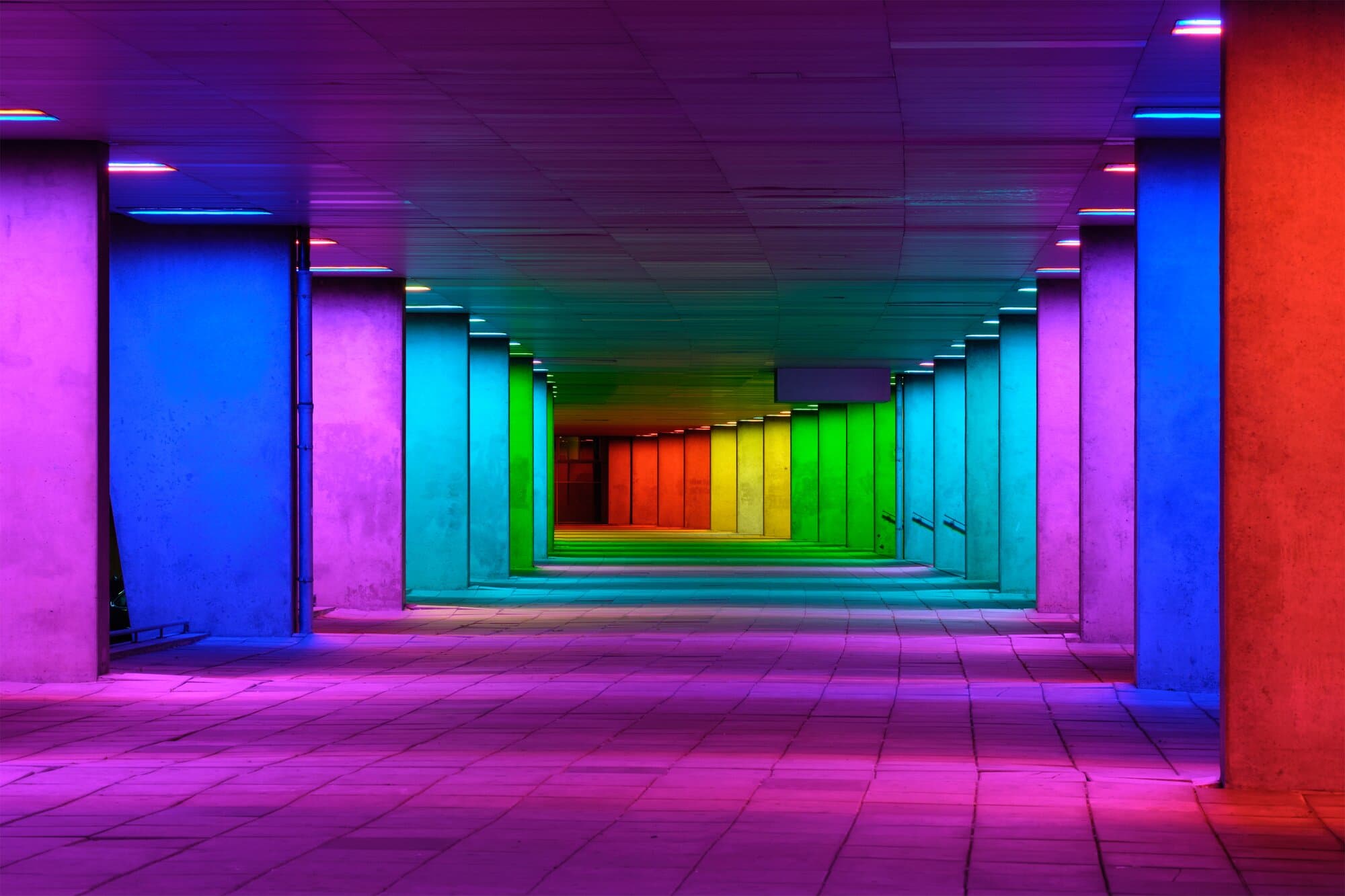 Concrete corridor lit in rainbow colours